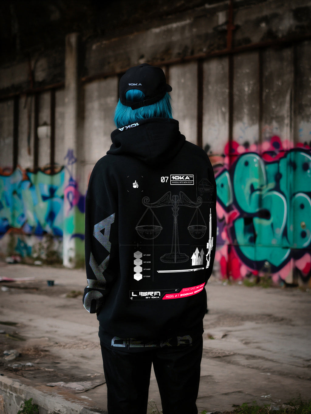 Model wearing the Zodiac Hoodie Libra by 10KA in an urban setting, back view, showcasing clean futuristic graphics inspired by Libra balance and harmony.
