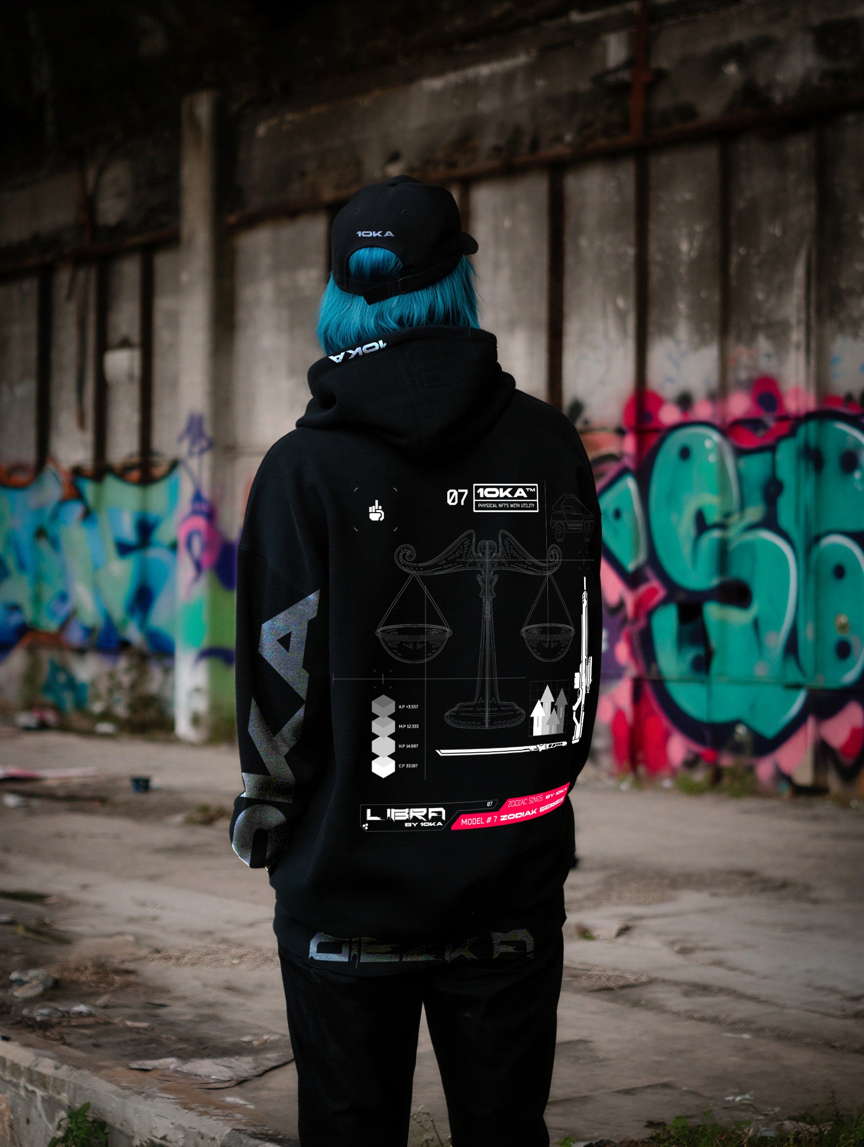 Model wearing the Zodiac Hoodie Libra by 10KA in an urban setting, back view, showcasing clean futuristic graphics inspired by Libra balance and harmony.
