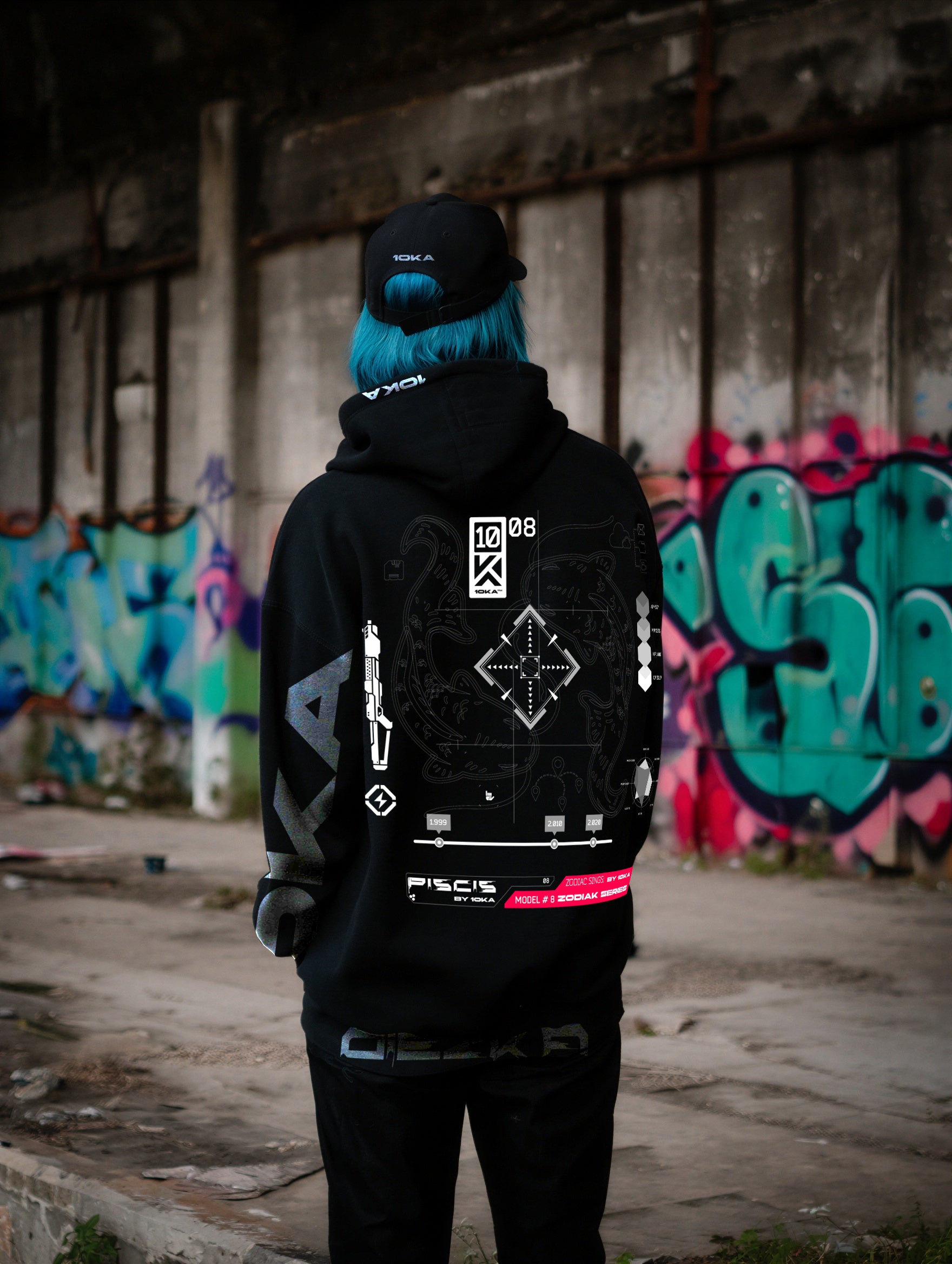 Model wearing the Zodiac Hoodie Pisces by 10KA in an urban setting, back view, showcasing ethereal futuristic graphics inspired by intuition and transcendence.
